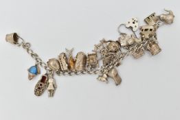 A HEAVY SILVER CHARM BRACELET, curb link bracelet fitted with multiple charms in forms such as a