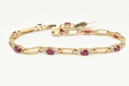 A YELLOW METAL RUBY AND DIAMOND LINE BRACELET, designed as a series of open work links,