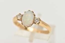 AN 18CT YELLOW GOLD, OPAL AND DIAMOND RING, designed as a central oval cut opal cabochon, claw