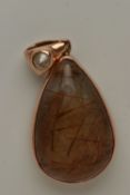 A 9CT GOLD GEM SET PENDANT, a large teardrop rutilated quartz cabochon, collet set in rose gold,