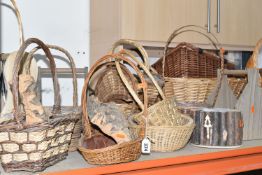 A LARGE QUANTITY OF WICKER BASKETS, comprising wicker flower baskets, a small hamper, a shopping