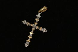 A YELLOW METAL DIAMOND PENDANT, designed as a cross, set with round brilliant and tapered baguette
