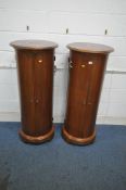A PAIR OF REPRODUCTION MAHOGANY CYLINDRICAL DOUBLE DOOR CABINETS, enclosing an arrangement of