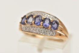 A 9CT GOLD TANZANITE AND DIAMOND RING, designed with a central row of five oval cut tanzanite's,
