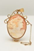 A YELLOW METAL CAMEO PENDANT, of an oval form, carved shell cameo depicting a lady in profile,
