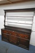 A GEORGIAN OAK DRESSER, with a triple plate rack, with an arrangement of five drawers, and two