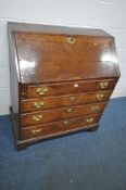A GEORGIAN OAK BUREAU, the fall front door enclosing a fitted interior, above four drawers, raised