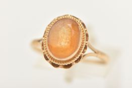 A YELLOW METAL CITRINE RING, set with an oval cut citrine in a collet setting with rope twist