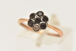 A YELLOW METAL CLUSTER RING, flower shape cluster set with six circular cut brown stones and one