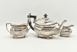A GEORGE V THREE PIECE SILVER TEA SET, comprising of a tea pot fitted with an ebonised handle and