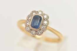 AN 18CT GOLD SAPPHIRE AND DIAMOND CLUSTER RING, centering on an emerald cut blue sapphire, collet
