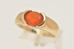 A 9CT GOLD GEM SET RING, an oval cut faceted orange stone, assessed as fire opal, half bezel set
