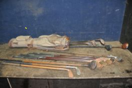 A VINTAGE GOLF BAG CONTAINING VINTAGE CLUBS including two Hickory shafted putter and one wood, six