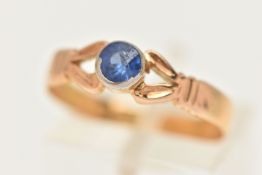 A 22CT GEM SET RING, a circular cut blue stone, bezel set in yellow gold, leading on to bifurcated