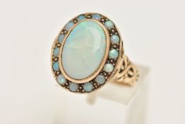 A YELLOW METAL OPAL LOCKET RING, a large AF oval opal collet set in yellow metal, set with a