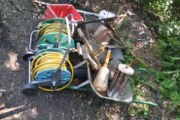 A SELECTION OF GARDEN TOOLS including two wheel barrows (one tyre flat), two hose reels, shovels,