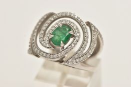 A PLATINUM EMERALD AND DIAMOND DRESS RING, large dress ring set with a central oval cut emerald,