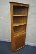 LUCIAN ERCOLANI, A MID CENTURY ELM AND BEECH CORNER CUBPOARD, fitted with two shelves, above a