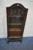 A 20TH CENTURY OAK BOOKCASE, with an arched top, the astragal glazed door enclosing three adjustable