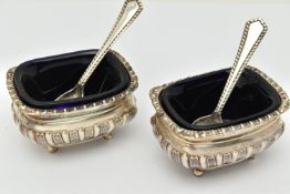 TWO SILVER SALTS WITH SPOONS, two rectangular embossed salts with gadrooned rims, both raised on