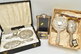 TWO BOXED SILVER VANITY SETS AND TWO SILVER PHOTO FRAMES, the vanity set comprising of a hair brush,