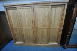 A LARGE MODERN PINE WARDROBE, fitted with two pairs of sliding doors, width 234cm x depth 58cm x