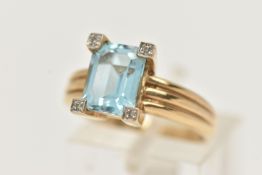 A 9CT GOLD TOPAZ AND DIAMOND RING, centering on a rectangular cut blue topaz, four claw set with