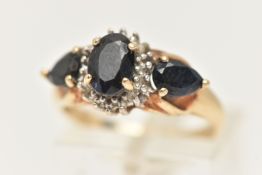 A 9CT GOLD SAPPHRIE AND DIAMOND RING, set with a central oval cut deep blue sapphire four claw set