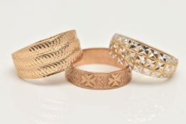 TWO 9CT GOLD RINGS AND A YELLOW METAL RING, the first a wide tapering band ring with textured