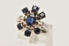 A SAPPHIRE AND DIAMOND DRESS RING, designed as a central oval sapphire flanked by two single cut