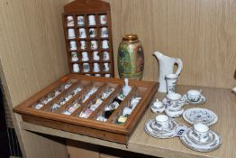A COLLECTION OF PORCELAIN THIMBLES AND MINIATURE TEA SET, comprising two small wooden display cases,