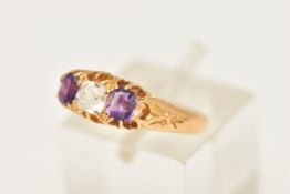 AN 18CT GOLD AMETHYST AND PASTE RING, set with a cushion cut colourless paste, flanked with two