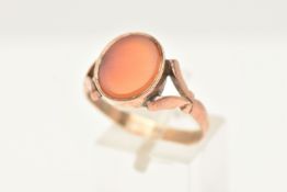 AN EARLY 20TH CENTURY CARNELIAN RING, set with an oval carnelian panel, to the split scroll design