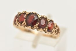 A 9CT GOLD FIVE STONE GARNET RING, designed as a graduated line of five oval cut garnets with