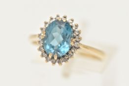 A 9CT GOLD TOPAZ AND DIAMOND RING, designed as an oval blue topaz within a single cut diamond