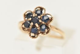 A 9CT GOLD SAPPHIRE CLUSTER RING, designed as a cluster of circular cur sapphires within a shaped