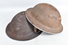 TWO WWII ERA STEEL HELMETS, the first has a liner and chin strap but has some surface rust, the