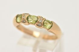 A 9CT GOLD PERIDOT AND DIAMOND DRESS RING, set with three oval cut peridots with single cut