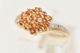 A 9CT GOLD CITRINE AND DIAMOND RING, designed as a cluster of circular cut Citrine, cross over