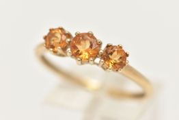 A 9CT GOLD CITRINE RING, set with three circular cut citrines, each in a claw setting, leading
