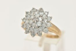 A 9CT GOLD CLUSTER RING, large circular cluster set with circular cut light blue stones, each claw