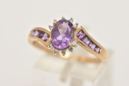 A 9CT GOLD AMETHYST AND DIAMOND DRESS RING, set with a central oval cut amethyst, in a surround of