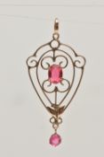 A YELLOW METAL LAVALIER PENDANT, an open work teardrop form pendant, set with an oval cut pink paste