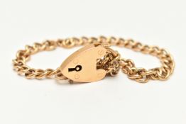 A YELLOW METAL BRACELET, a curb link chain bracelet fitted with a heart padlock clasp, stamped