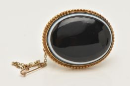 A VICTORIAN BULLS EYE AGATE BROOCH, of an oval form, set with a bulls eye agate cabochon collet