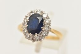 A YELLOW METAL SAPPHIRE AND DIAMOND CLUSTER RING, set with a central oval cut deep blue sapphire,