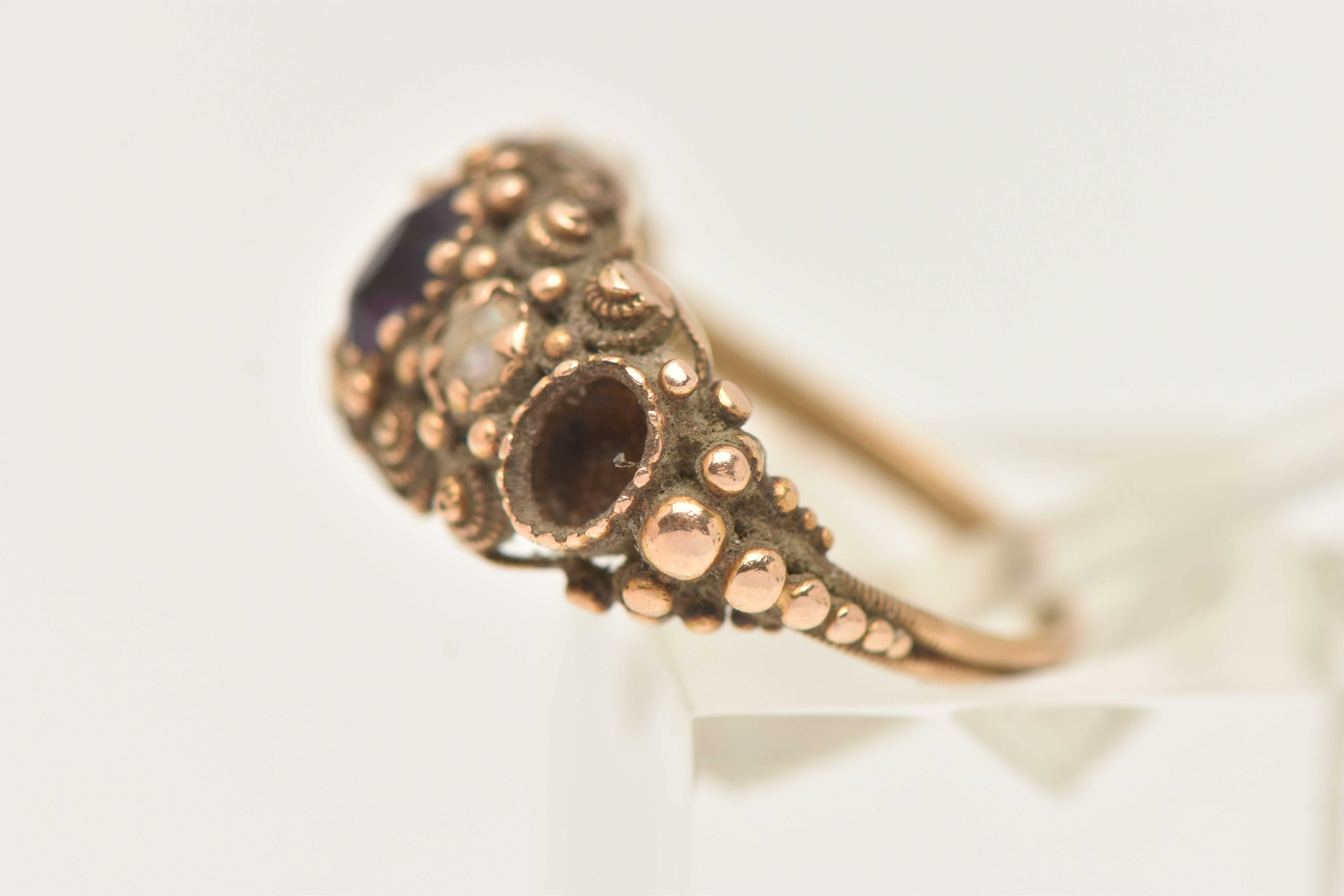 A YELLOW METAL GEM SET RING, AF set with two oval cut amethysts (one missing) and a single split - Image 2 of 6