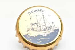 A GEORG JENSEN NOVELTY BOTTLE OPENER, designed as a bottle top with a blue ship and 'Danmark' detail