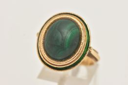 A YELLOW METAL MALACHITE AND GREEN ENAMEL DRESS RING, of an oval form set with an oval cut malachite
