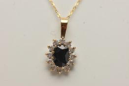A SAPPHIRE CLUSTER PENDANT AND CHAIN, designed as a central oval sapphire within a colourless